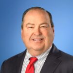 Ken Entenmann headshot on blue background