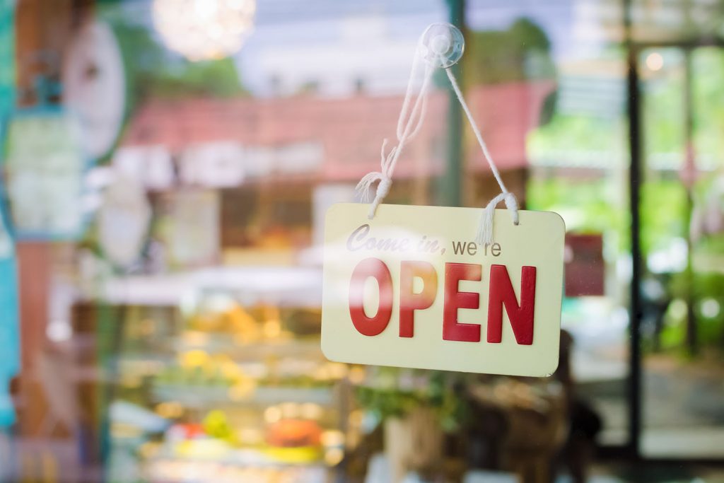 Open sign broad through the glass of door in cafe. Business and service concept.